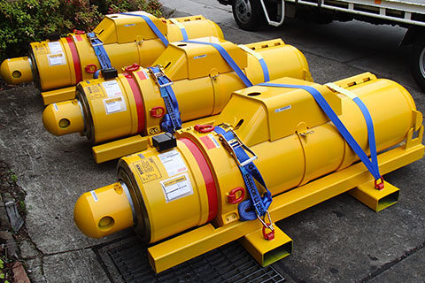 a man lifting a hydraulic cylinder in a warehouse